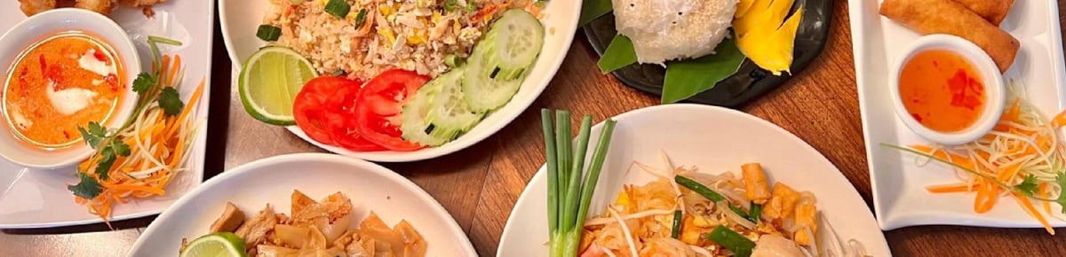 Appetizers, fried rice and mango sticky rice laid out on a table