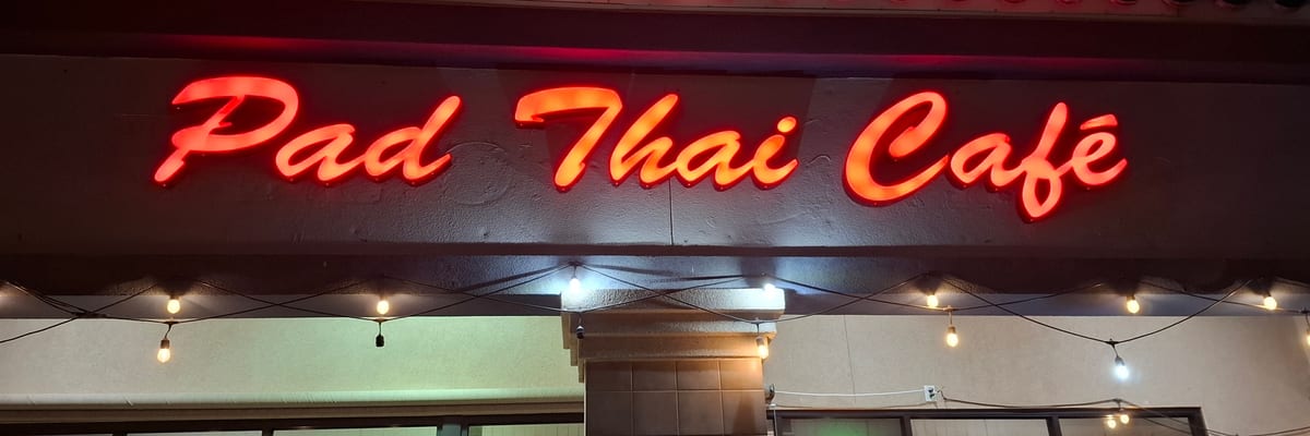 The lit Pad Thai Café sign above the restaurant entrance at night